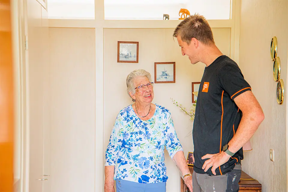 Vakman met bewoner in de woning